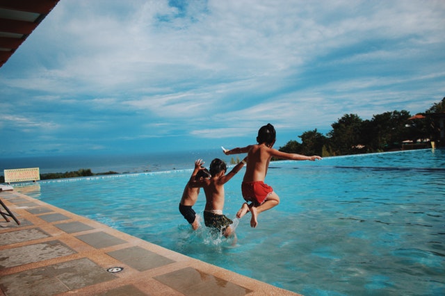 děti skáčou do bazénu